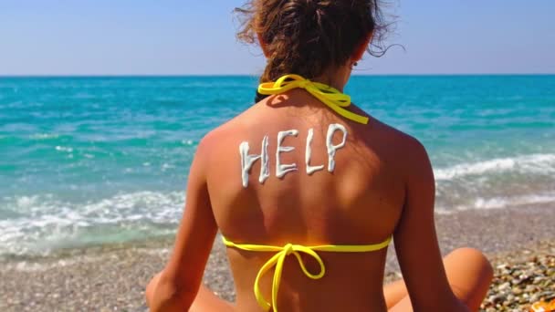 The child puts sunscreen on her back. Selective focus. — Stockvideo