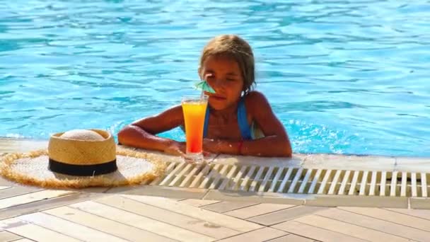 El niño está bebiendo un cóctel junto a la piscina. Enfoque selectivo. — Vídeo de stock