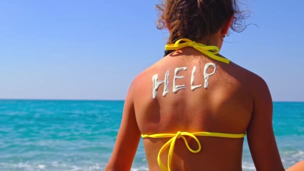 The child puts sunscreen on her back. Selective focus. — Vídeo de stock