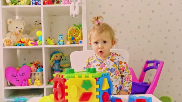 아이는 방 안에서 장난감을 가지고 놀고 있습니다. 선택적 초점. — 비디오