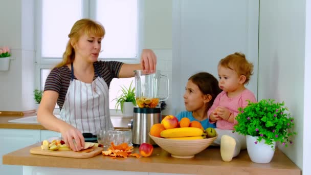 Die Familie bereitet Smoothies zu Hause zu. Selektiver Fokus. — Stockvideo