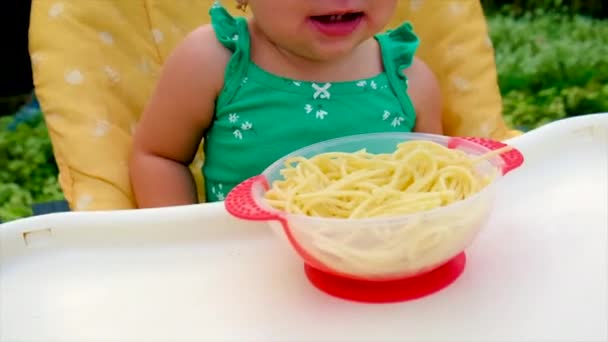Baby eet zelf spaghetti. Selectieve focus. — Stockvideo