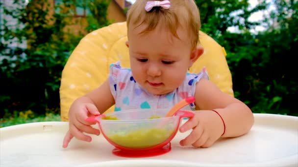 Малюк їсть пюре брокколі. Вибірковий фокус . — стокове відео