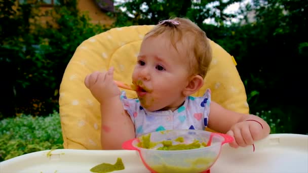 Baby is eating broccoli puree. Selective focus. — Stockvideo