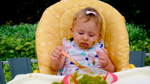 Baby is eating broccoli puree. Selective focus. — Stock Video