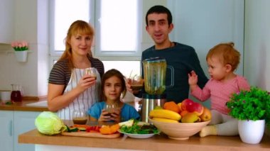 Aile evde smoothie hazırlar. Seçici odak.