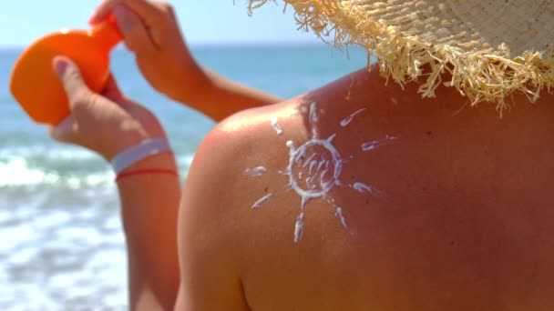 Жінка на пляжі мазає сонцезахисним кремом. Вибірковий фокус . — стокове відео