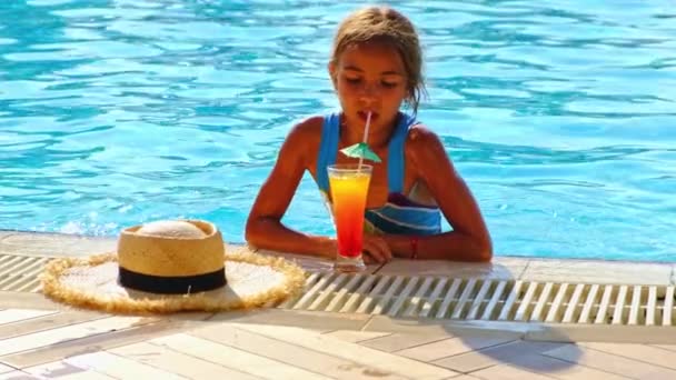 A criança está bebendo um coquetel na piscina. Foco seletivo. — Vídeo de Stock