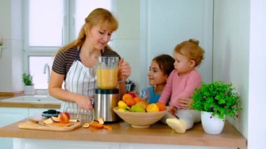 Aile evde smoothie hazırlar. Seçici odak.
