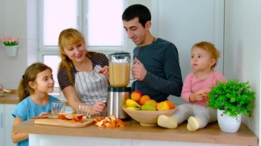 Aile evde smoothie hazırlar. Seçici odak.