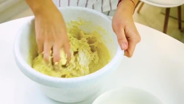 Жінка замішує тісто на кухні. Вибірковий фокус . — стокове відео