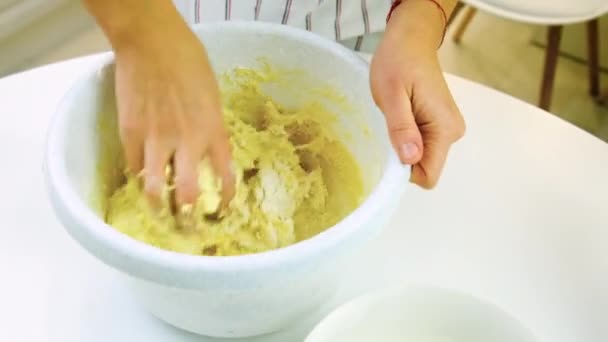 A woman is kneading dough in the kitchen. Selective focus. — Stock Video