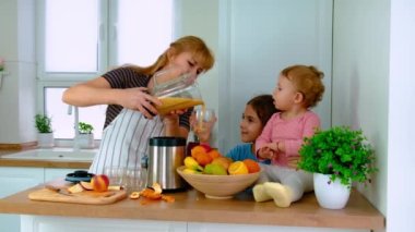 Aile evde smoothie hazırlar. Seçici odak.