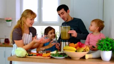 Aile evde smoothie hazırlar. Seçici odak.