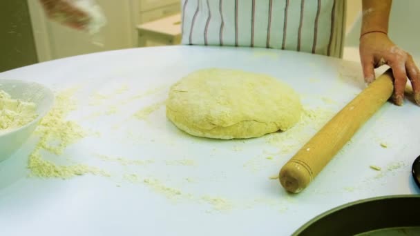 Une femme pétrit de la pâte dans la cuisine. Concentration sélective. — Video