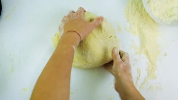 Une femme pétrit de la pâte dans la cuisine. Concentration sélective. — Video