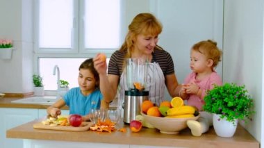 Aile evde smoothie hazırlar. Seçici odak.
