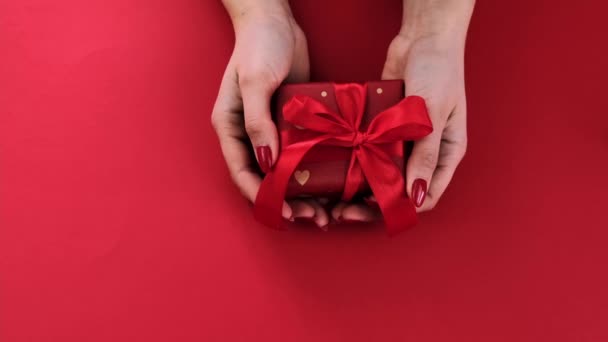 Ein Geschenk in den Händen einer Frau am Valentinstag. Selektiver Fokus. — Stockvideo
