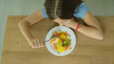 Çocuk haşlanmış sebze yiyor. Seçici odak.