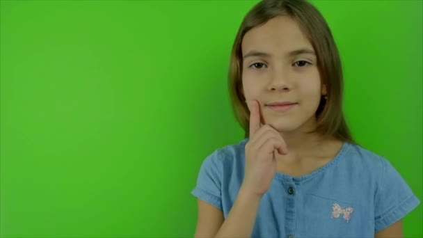 Lapsi ajattelee vihreällä taustalla. Valikoiva painopiste. — kuvapankkivideo