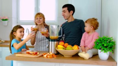 Aile evde smoothie hazırlar. Seçici odak.
