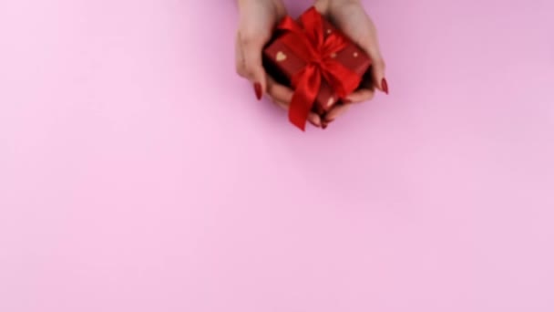 Un cadeau entre les mains d'une femme le jour de la Saint-Valentin. Concentration sélective. — Video