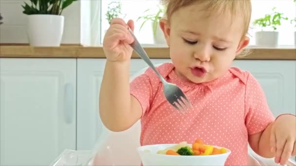 El bebé come verduras en una silla. Enfoque selectivo. — Vídeo de stock