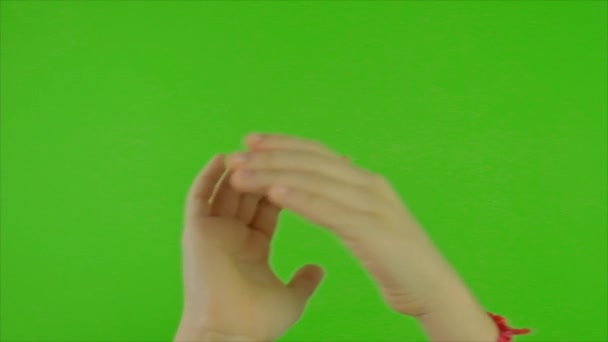 Mains d'un enfant acclamant sur un fond vert. Concentration sélective. — Video