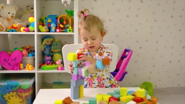 The child plays with toys in the room. Selective focus. — Stock Video