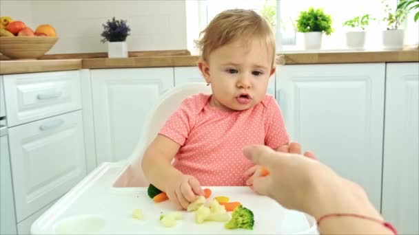 Ребенок ест овощи на стуле. Селективный фокус. — стоковое видео
