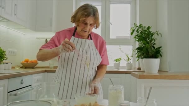 Grootmoeder bereidt deeg in de keuken. Selectieve focus. — Stockvideo