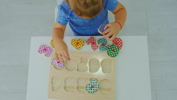 The child learns puzzle numbers. Selective focus. — Stock Video