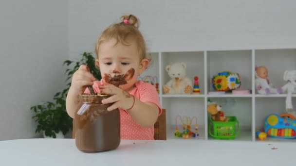 Ребенок ест шоколадную пасту. Селективный фокус. — стоковое видео