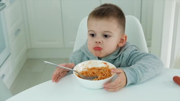 Il bambino mangia gli spaghetti in cucina. Focus selettivo. — Video Stock