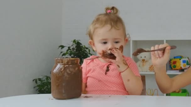 Ребенок ест шоколадную пасту. Селективный фокус. — стоковое видео