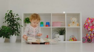 Bebek odada bir kitap okuyor. Seçici odak.