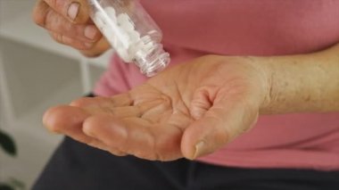 Yaşlı bir kadın hap içiyor. Seçici odak.