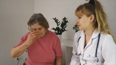Doktor yaşlı kadına haplar veriyor. Seçici odak.