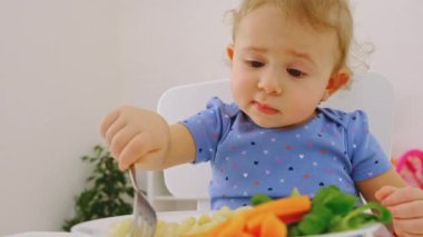Çocuk makarna ve sebze yiyor. Seçici odak.