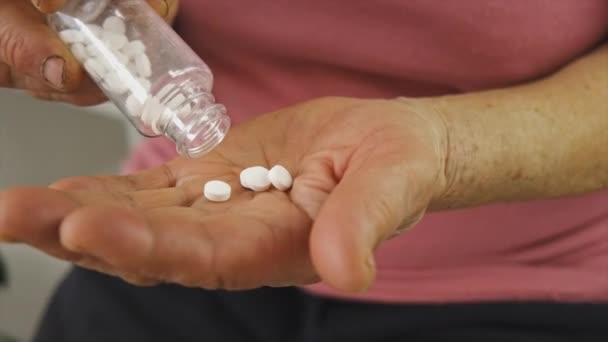 Een oude vrouw drinkt pillen. Selectieve focus. — Stockvideo