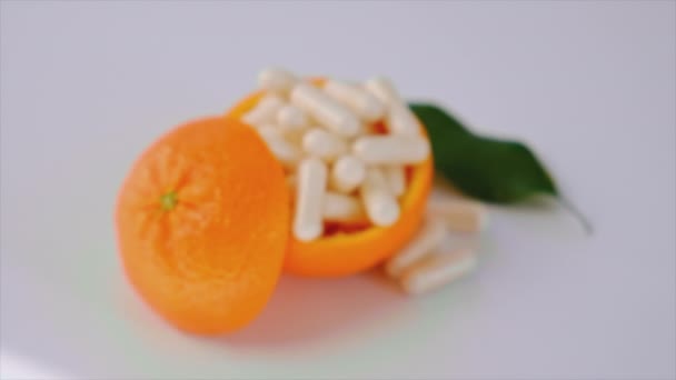 Vitamin C med apelsiner på vit bakgrund. Selektiv inriktning. — Stockvideo