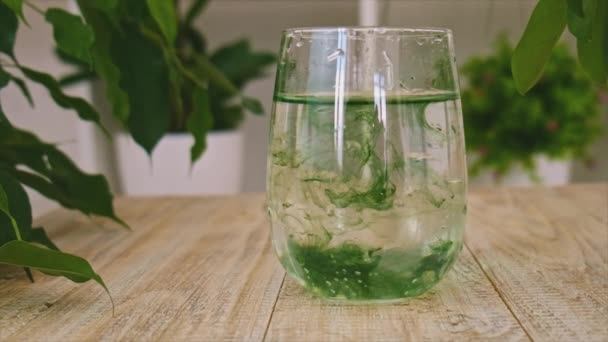 Tekutý chlorofyl ve sklenici vody. Selektivní zaměření. — Stock video