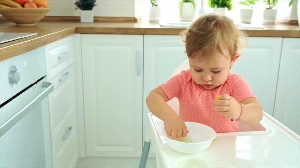 Dítě jí zeleninu na židli. Selektivní zaměření. — Stock video