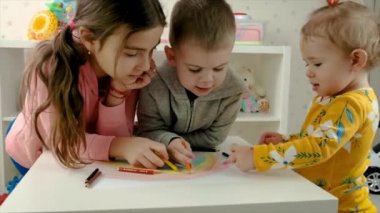 Çocuklar birlikte bir gökkuşağı çiziyorlar. Seçici odak.