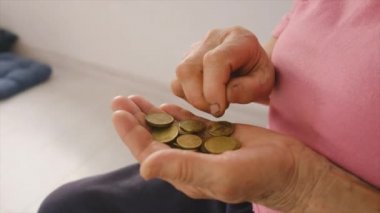 Zavallı yaşlı kadın parayı sayıyor. Seçici odak.
