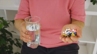 Yaşlı bir kadın hap içiyor. Seçici odak.