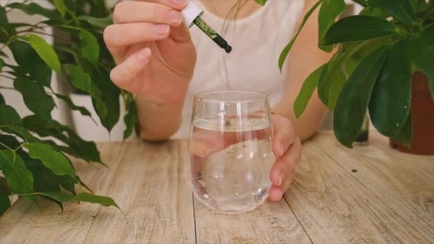 Clorofilla liquida in un bicchiere d'acqua. Focus selettivo. — Video Stock