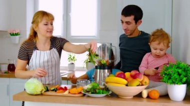 Aile evde smoothie hazırlar. Seçici odak.