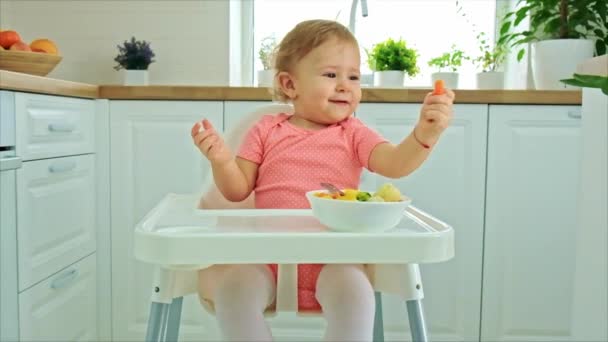 赤ん坊は椅子で野菜を食べる。選択的焦点. — ストック動画