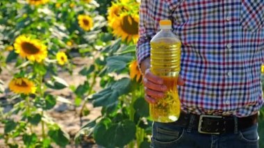 Bir adam elinde ayçiçeği yağı tutar. Seçici odak.